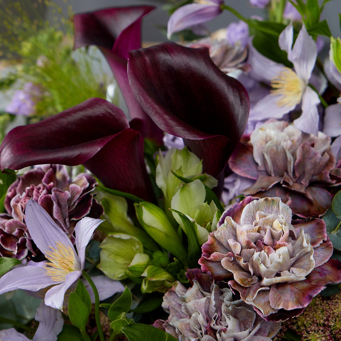stunning bouquet featuring Purple dyed carnation, calla lily, clematis & Greenery